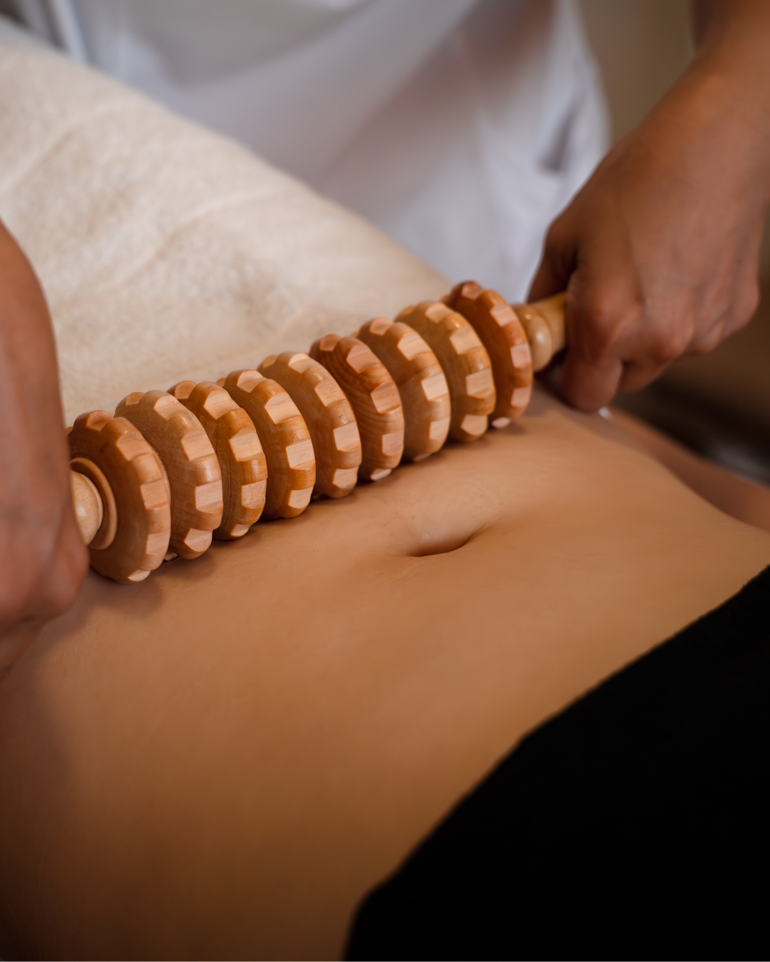 Therapist performing maderotherapy with wooden tools