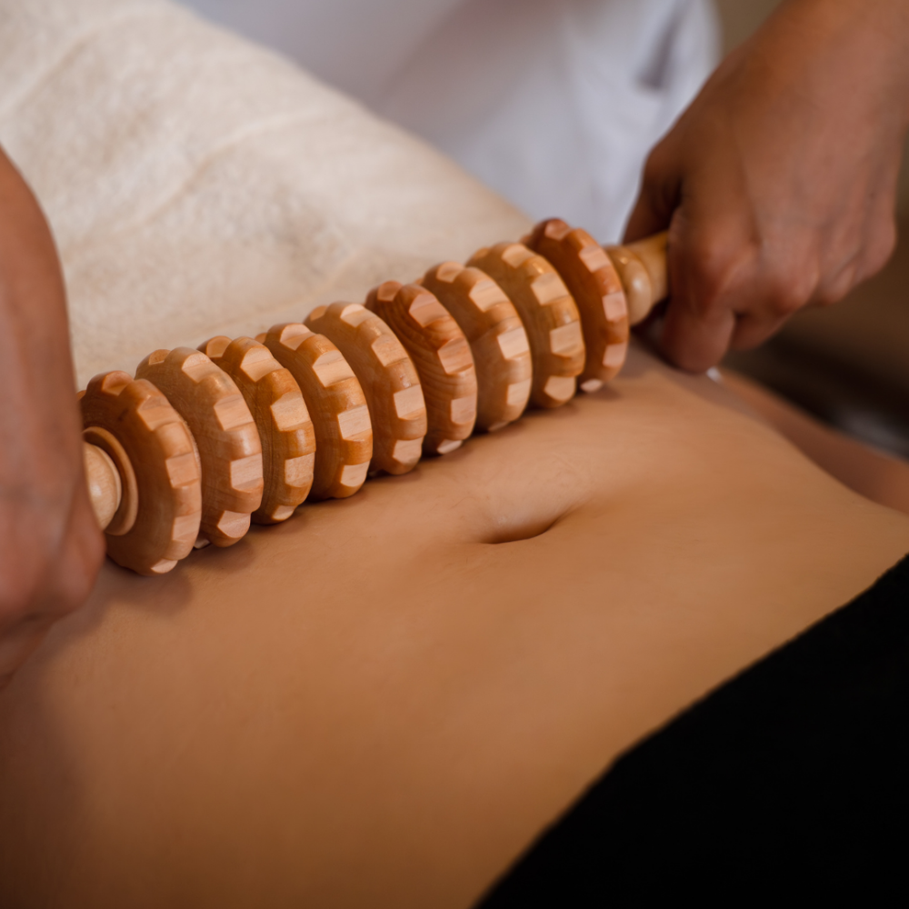 Therapist performing maderotherapy with wooden tools